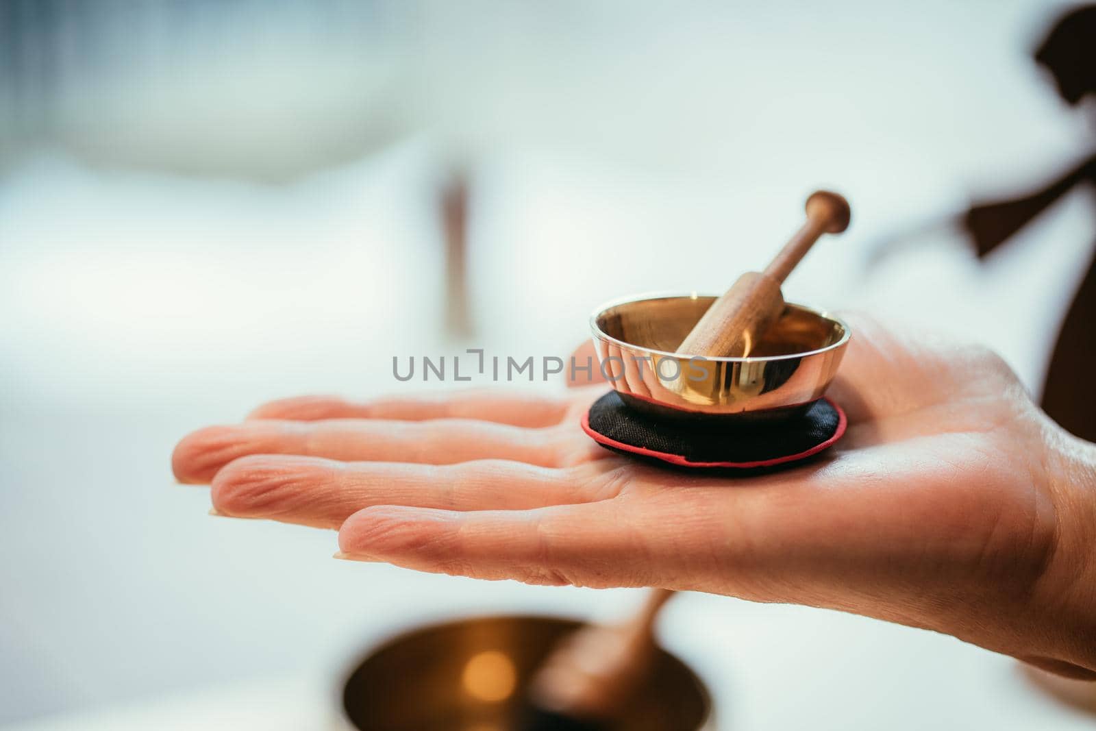 Small singing bowl holding in hand, blurry background