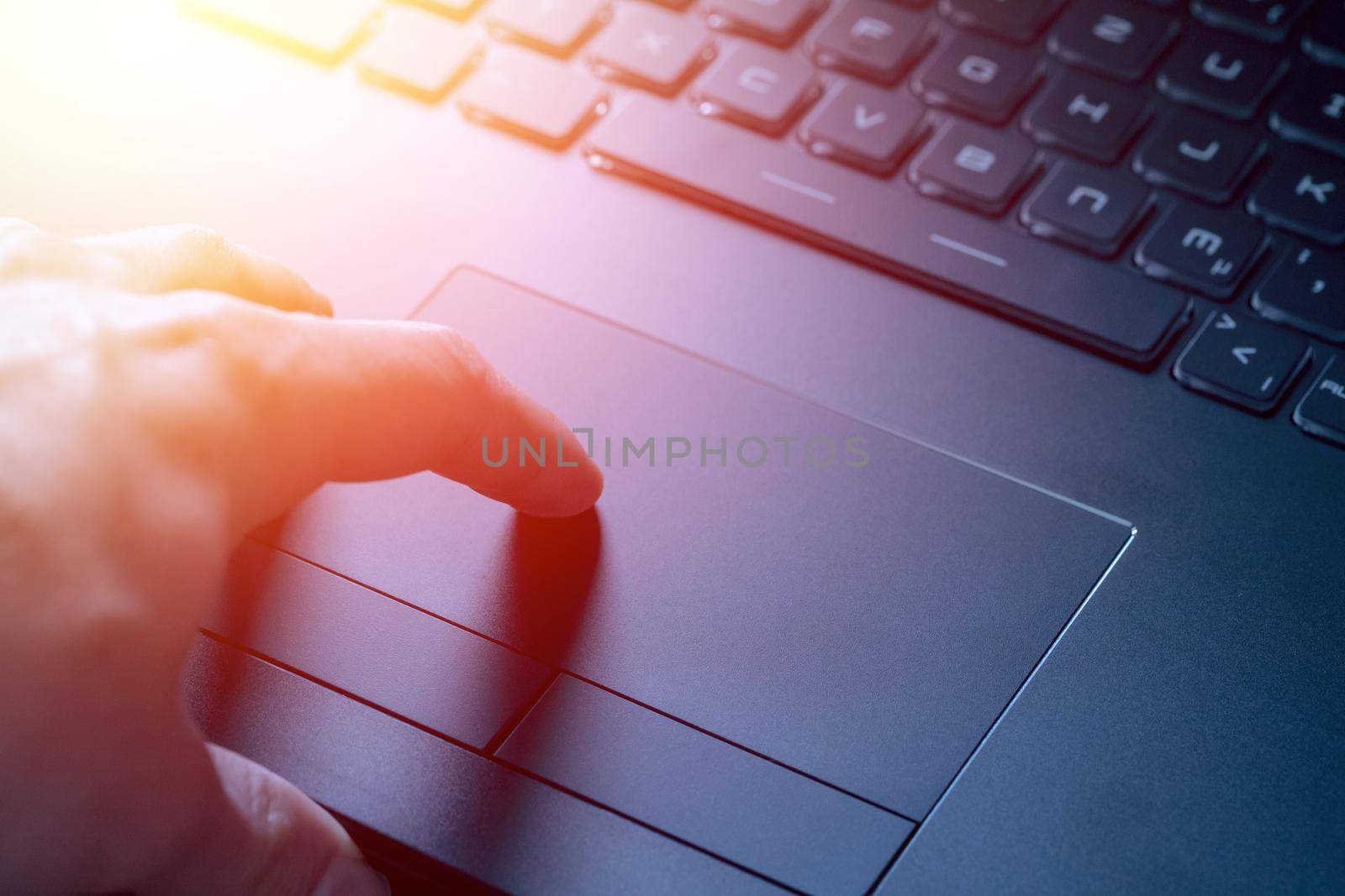 Close up picture of hands using a notebook touchpad, sunshine