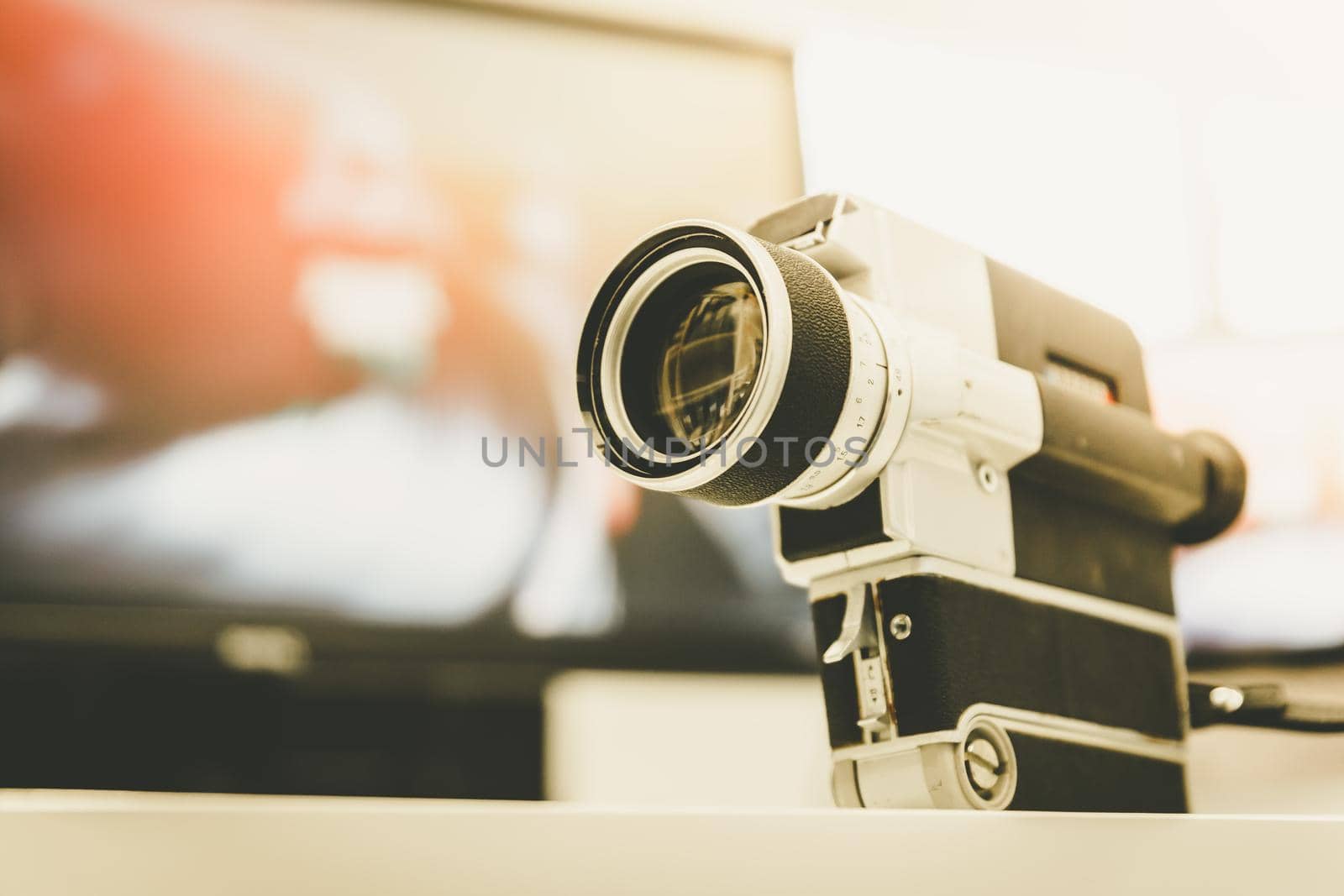 Movie production: vintage old movie camera on a desk, cutting room in the background. Sunshine. by Daxenbichler