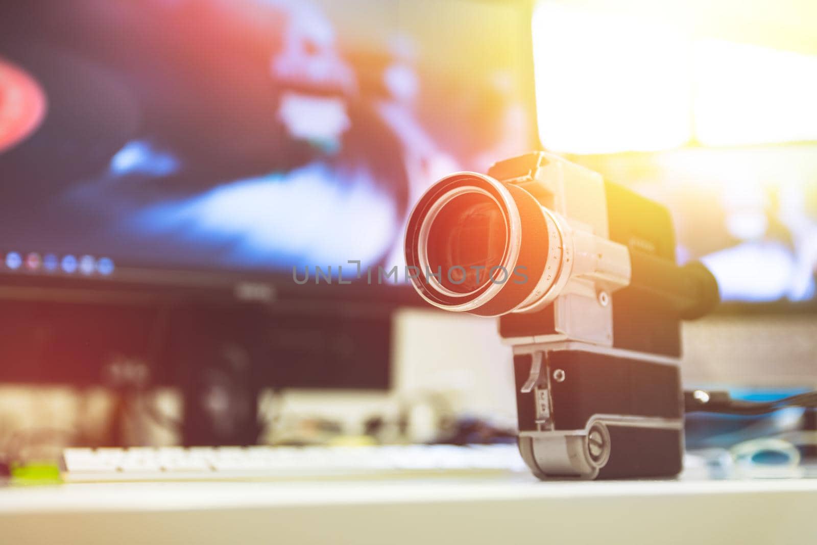 Movie production: vintage old movie camera on a desk, cutting room in the background. Sunshine. by Daxenbichler