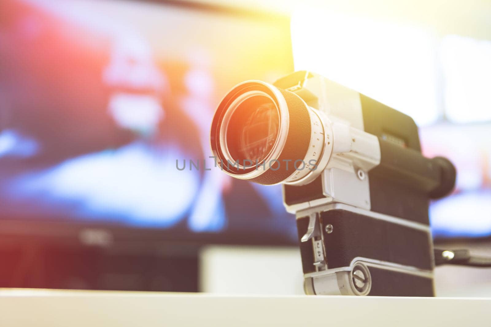 Movie production: vintage old movie camera on a desk, cutting room in the background. Sunshine. by Daxenbichler