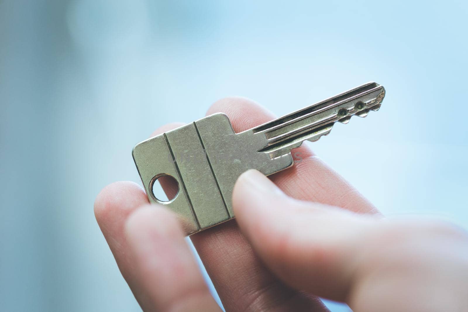 Holding a house key in the hand: New home and property.