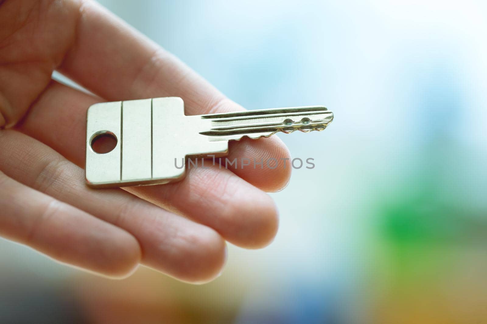 Holding a house key in the hand: New home and property.