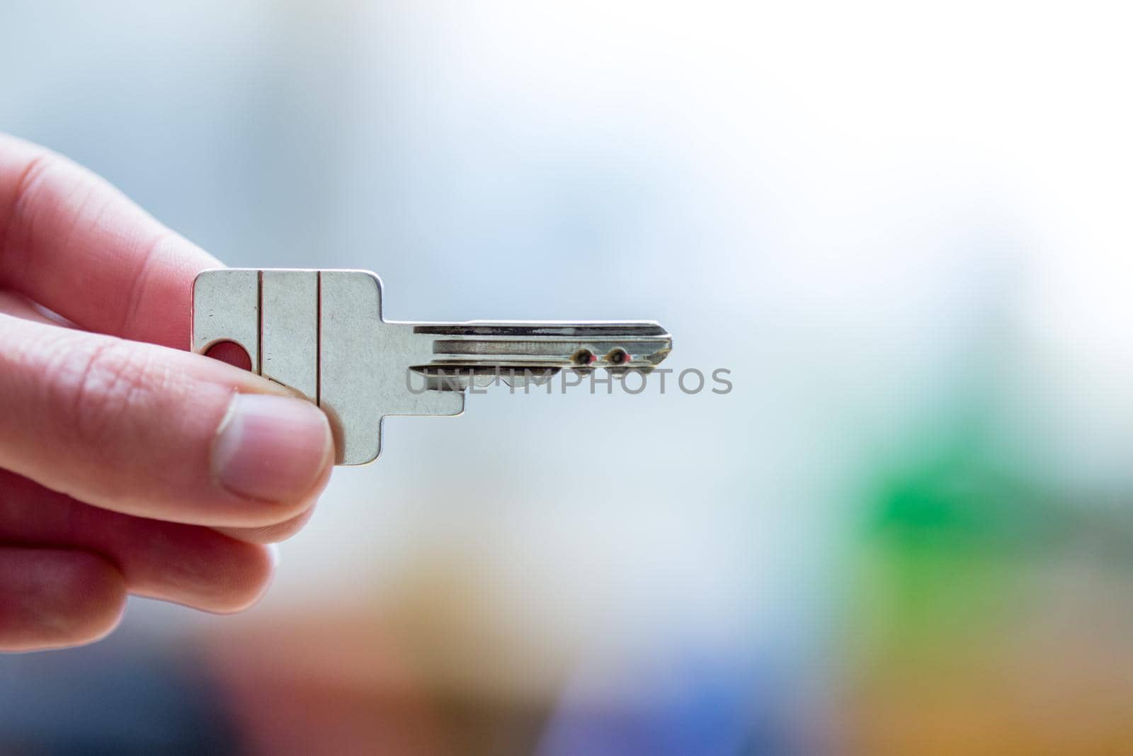 Holding a house key in the hand: New home and property.