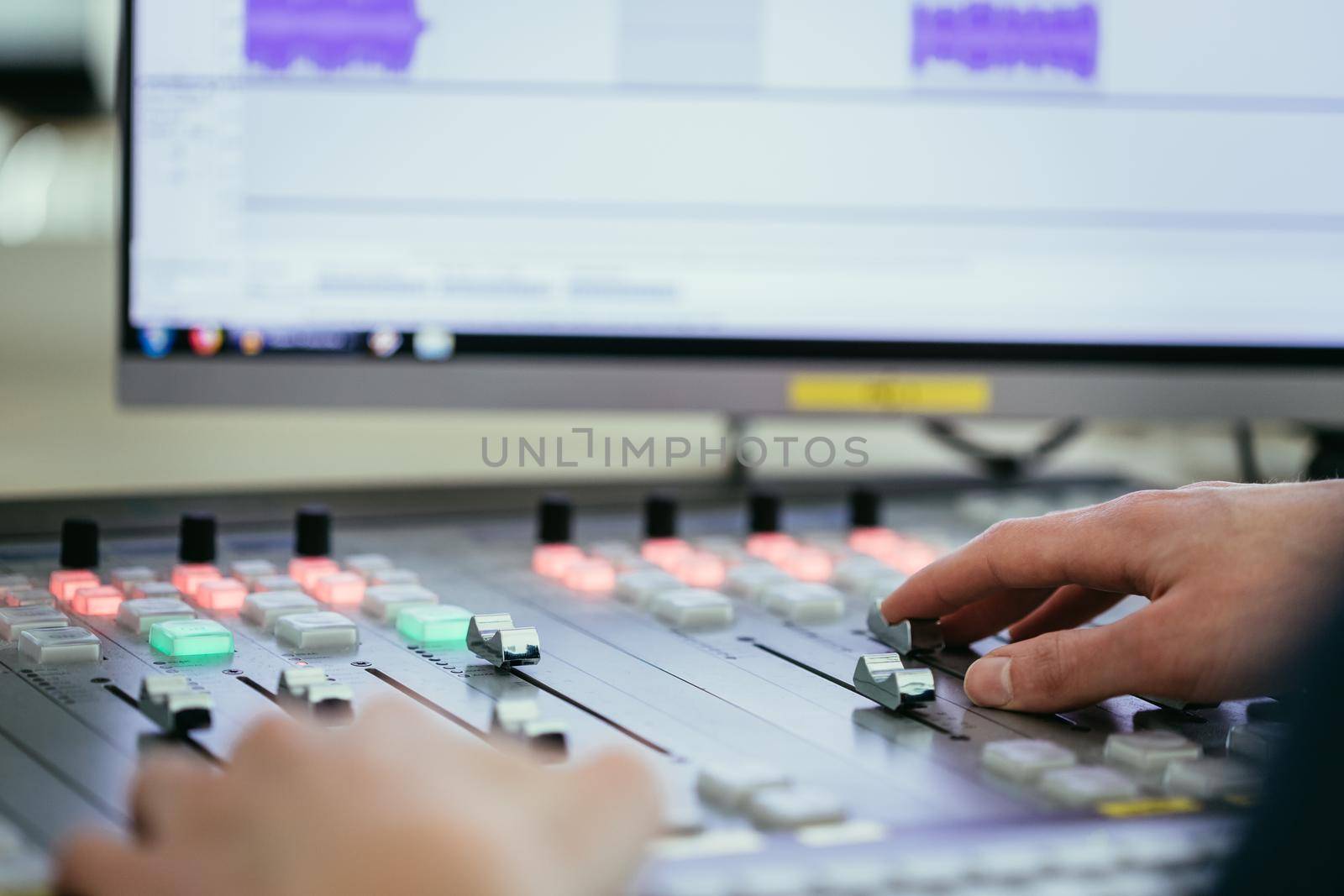 Moderator and soundboard in radio broadcasting studio