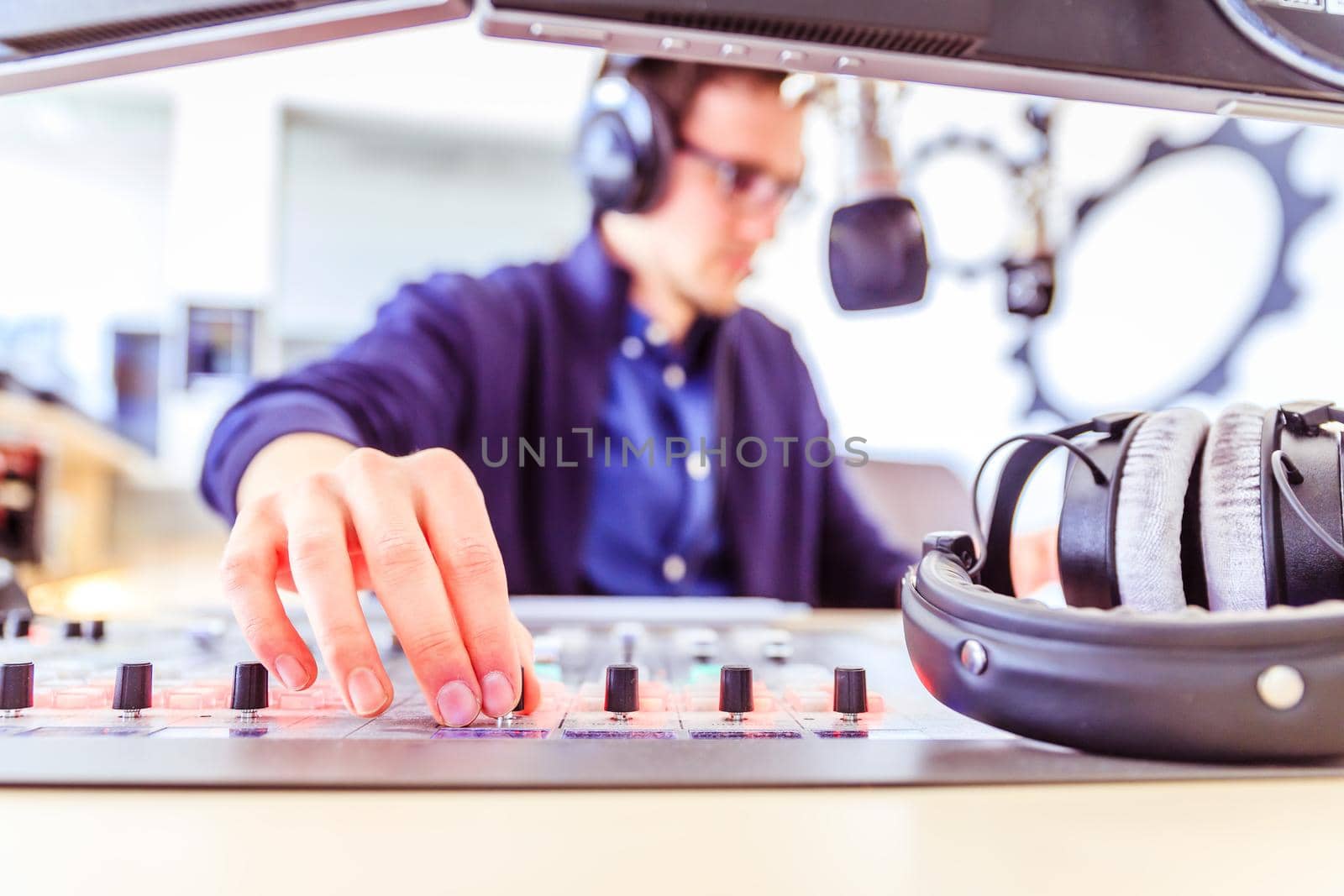 Young man in the broadcasting studio, radio, talking into the microphone