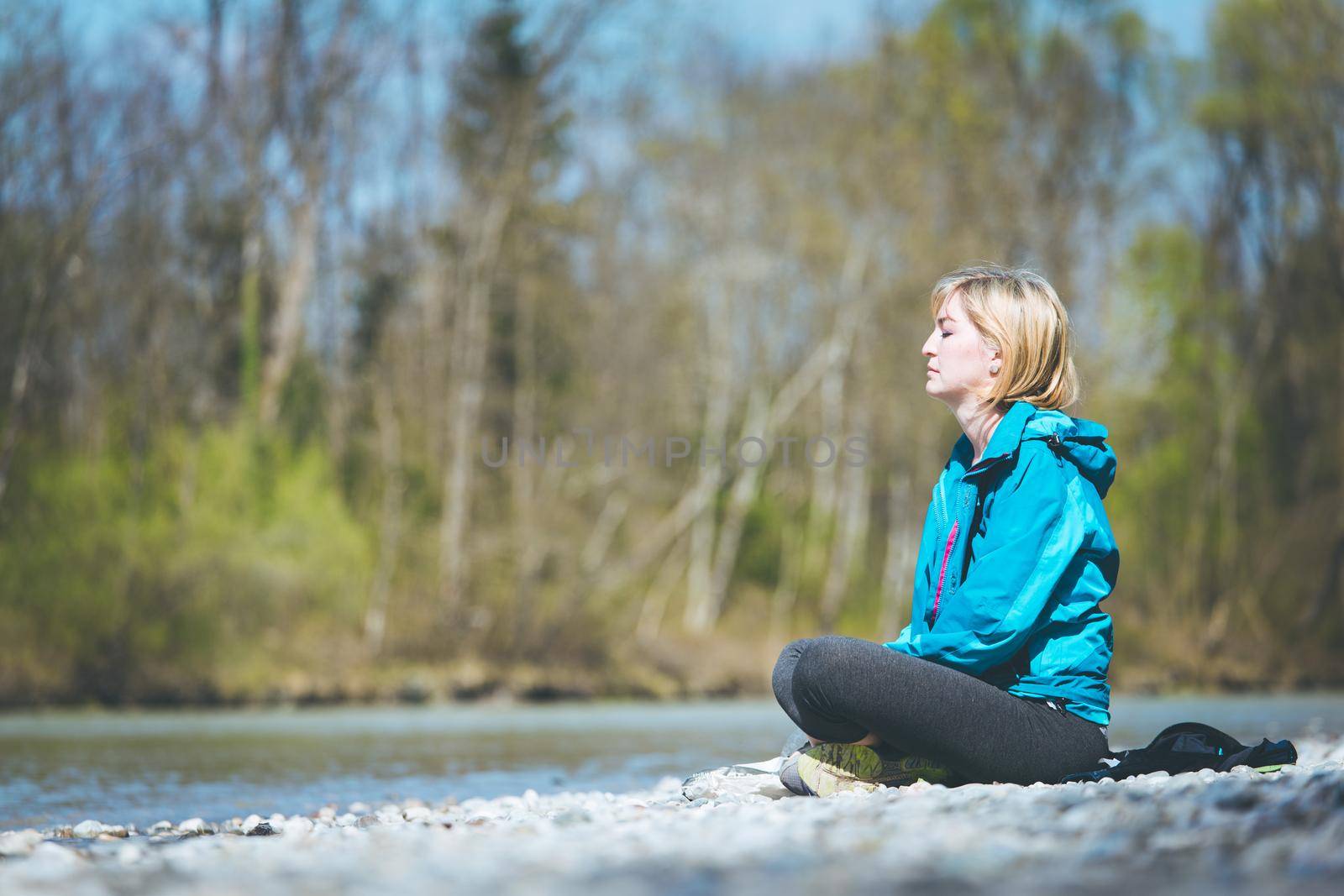 Meditation and relaxation: Woman is meditating outdoors on a pebble beach. Enjoying the summer. by Daxenbichler