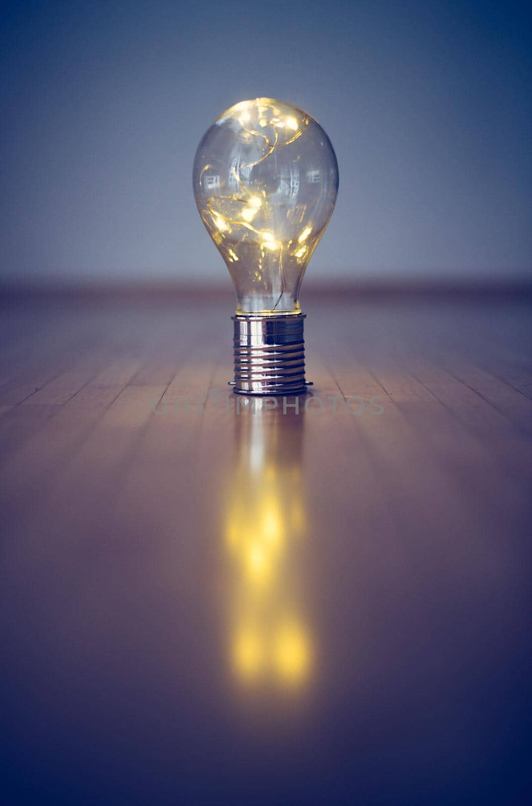 LED light bulb is lying on the wooden floor. Symbol for ideas and innovation. Copy space.