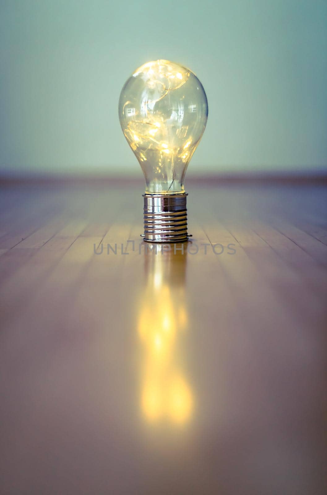 LED light bulb is lying on the wooden floor. Symbol for ideas and innovation. Copy space.