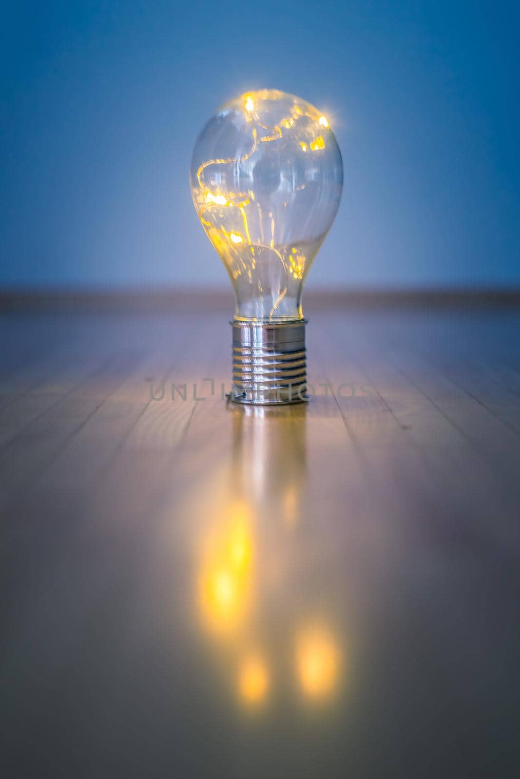 LED light bulb is lying on the wooden floor. Symbol for ideas and innovation. Copy space.