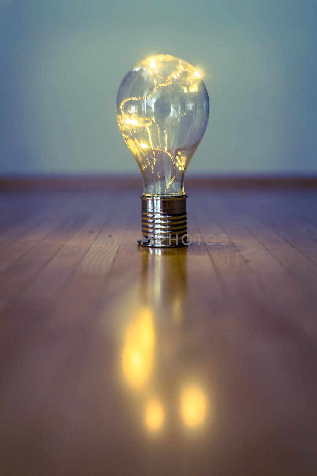 LED light bulb is lying on the wooden floor. Symbol for ideas and innovation. Copy space.