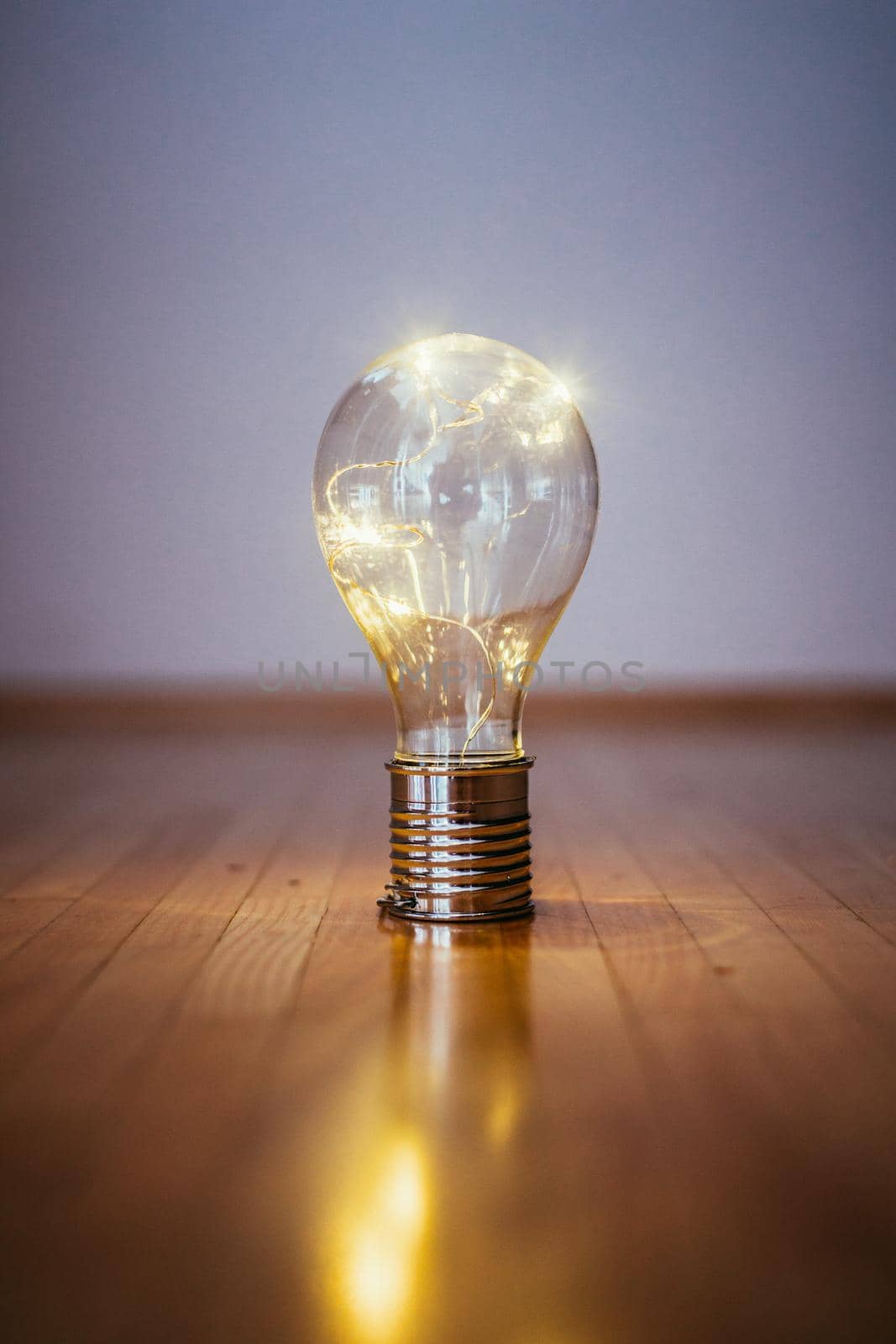 LED light bulb is lying on the wooden floor. Symbol for ideas and innovation. Copy space.