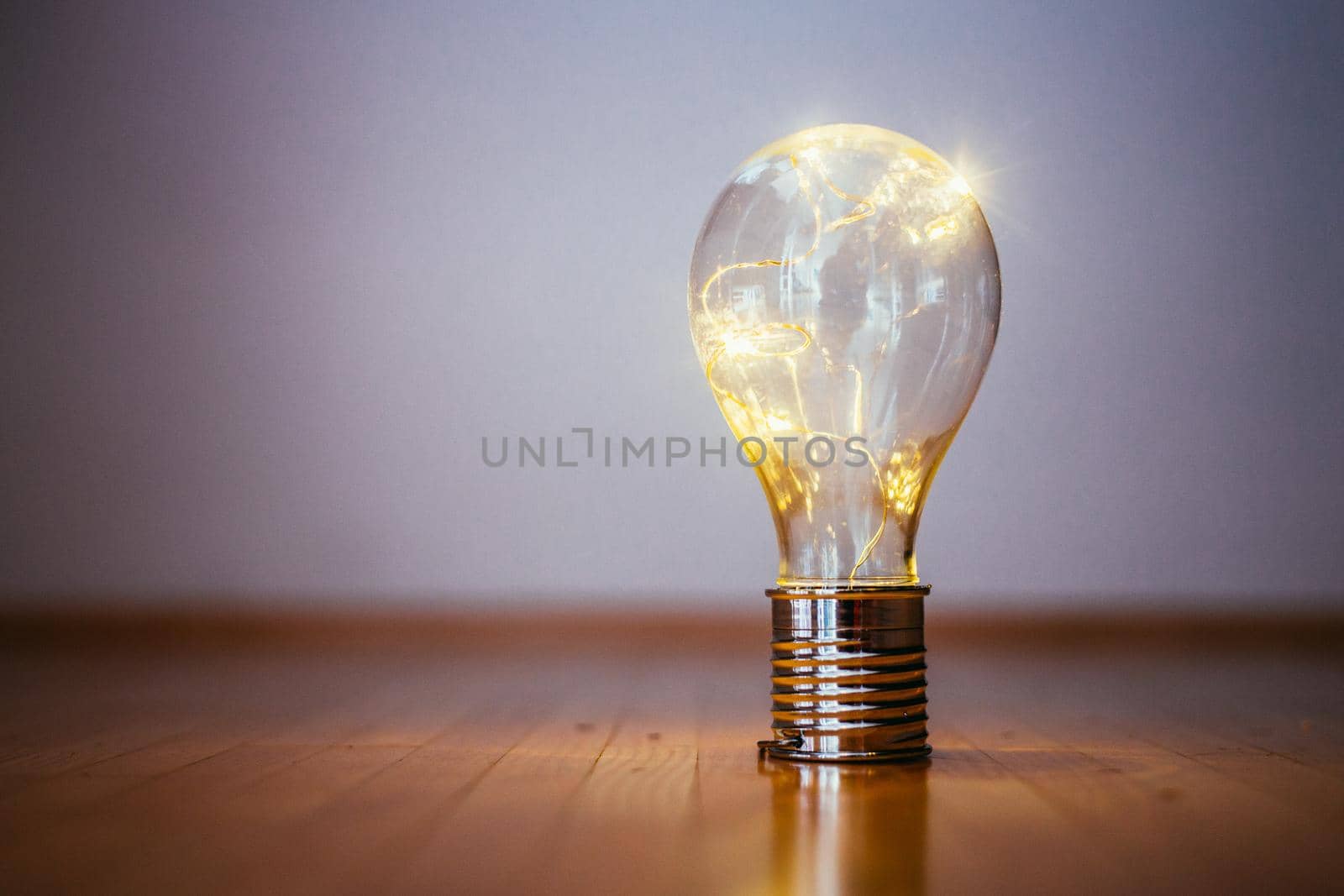 LED light bulb is lying on the wooden floor. Symbol for ideas and innovation. Copy space.