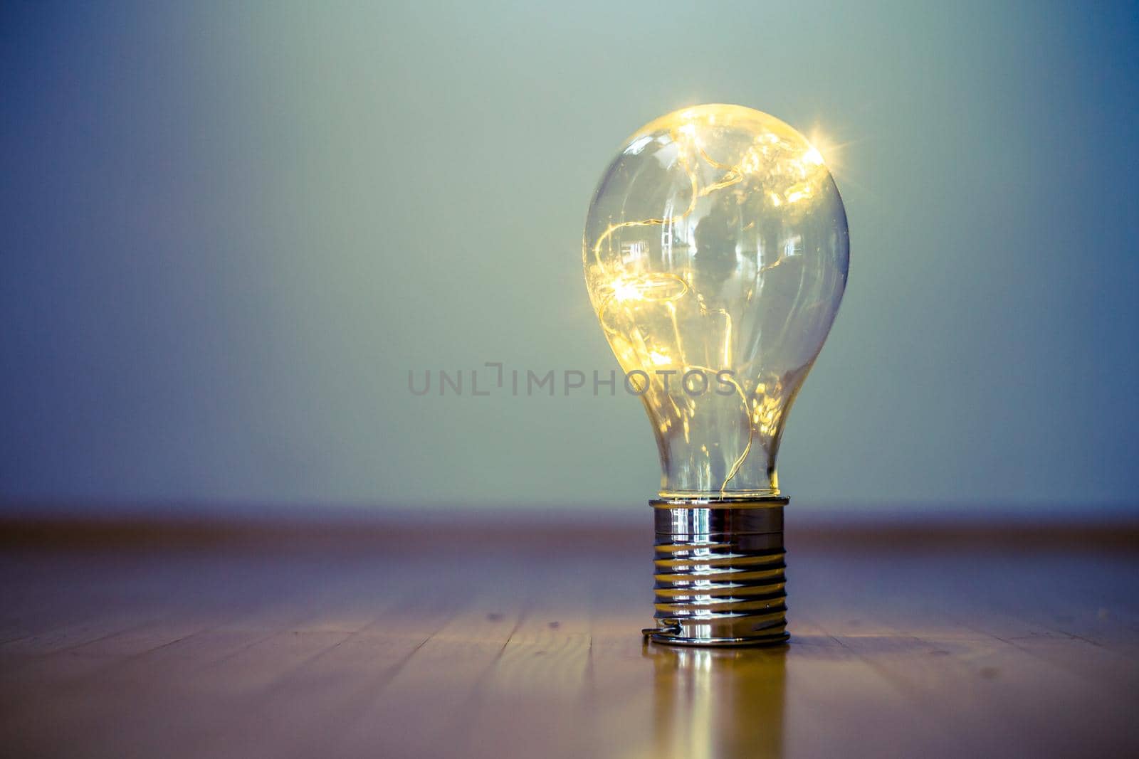 LED light bulb is lying on the wooden floor. Symbol for ideas and innovation. Copy space.