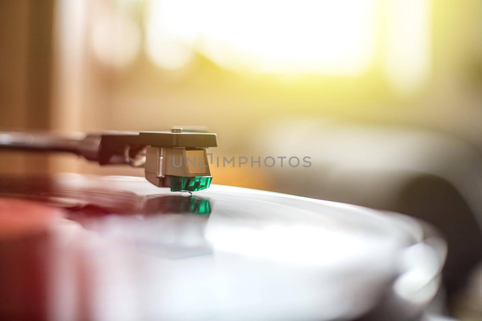 Close up picture of a record player, playing a record. Sunbeam.