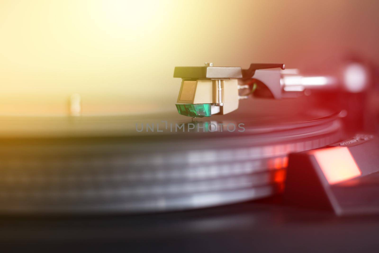 Close up picture of a record player, playing a record. Sunbeam.