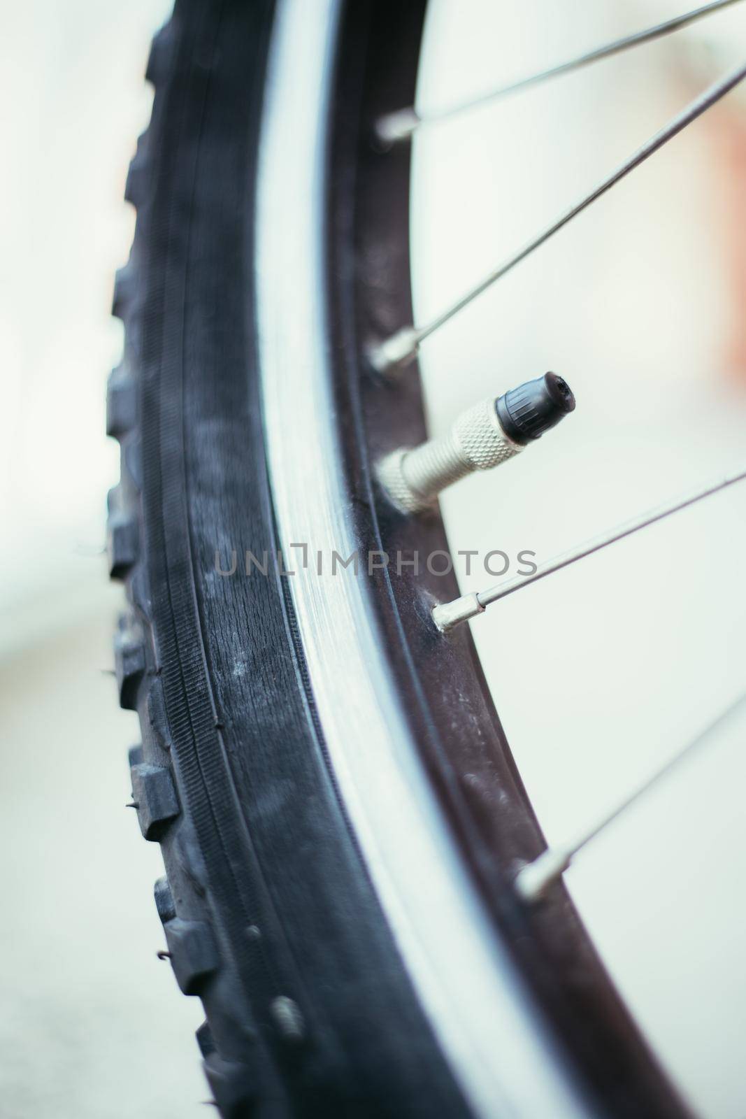 Close up picture of a bike tyre outlet and spokes, blurry background
