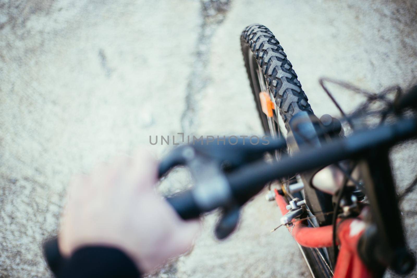 Close up picture of a mountain bike tyre, blurry handlebar, summer day