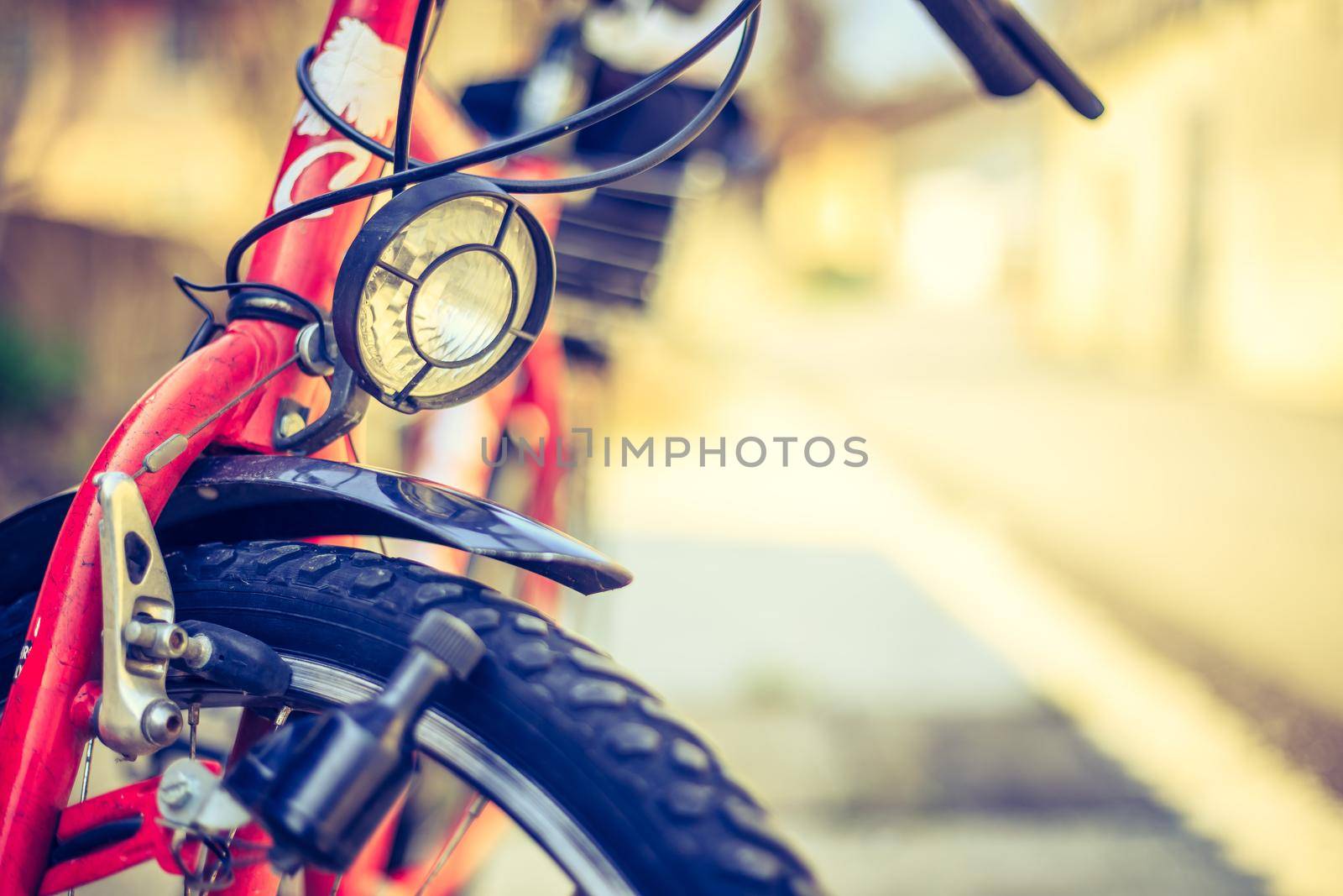 Front picture of a city bike, head lamp and blurry background