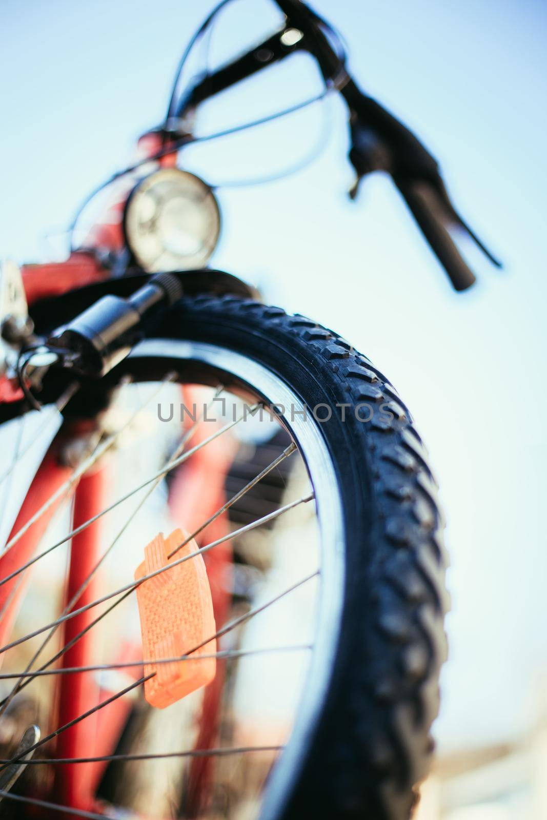 Close up picture of a mountain bike tyre, summer day. Bike in the blurry background.