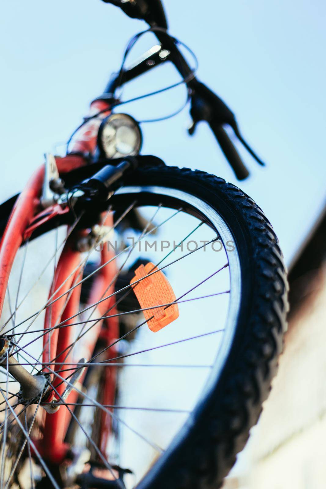 Close up of mountain bike tyres outside, summer day, city mobility. Bike in blurry background. by Daxenbichler