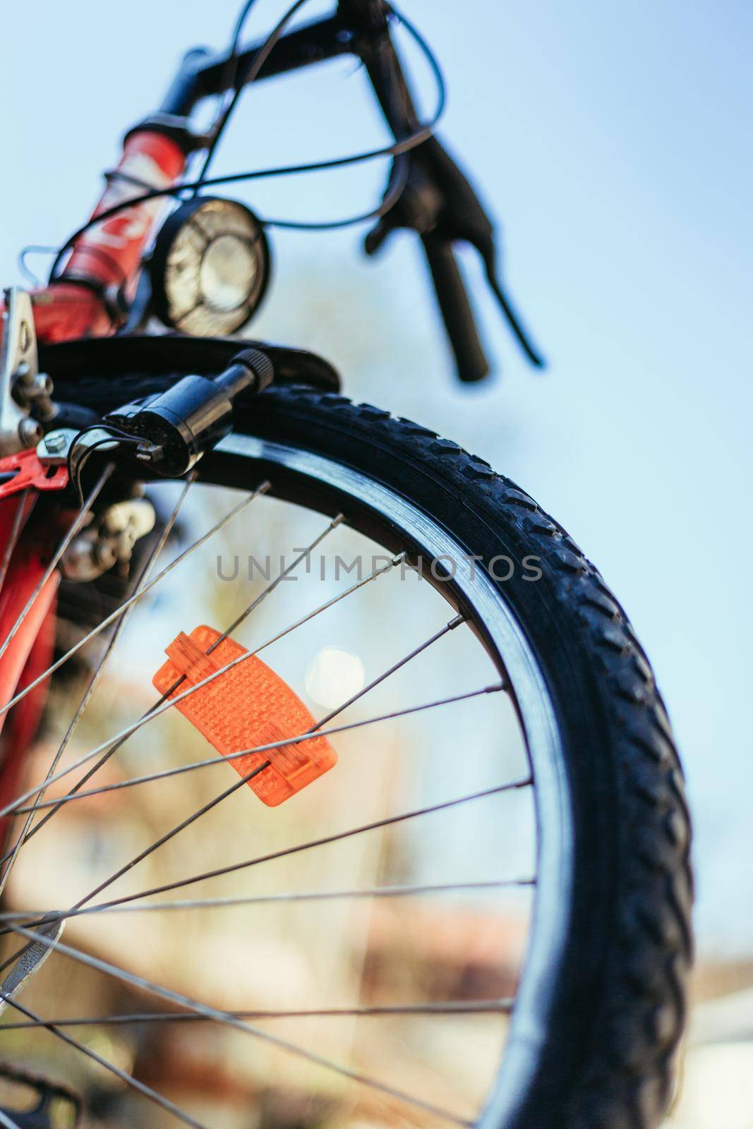 Close up picture of a mountain bike tyre, summer day. Bike in the blurry background.