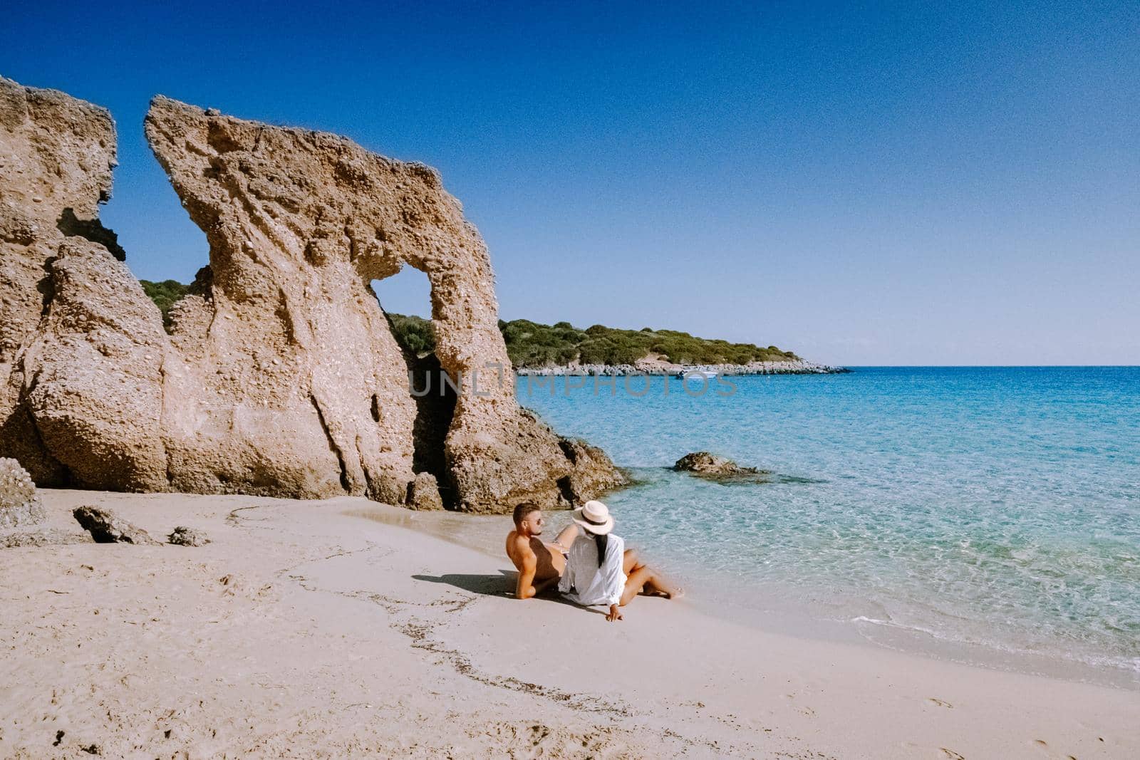 Tropical beach of Voulisma beach, Istron, Crete, Greece ,Most beautiful beaches of Crete island -Istron bay near Agios Nikolaos young couple mid age on vacation in Greece Crete