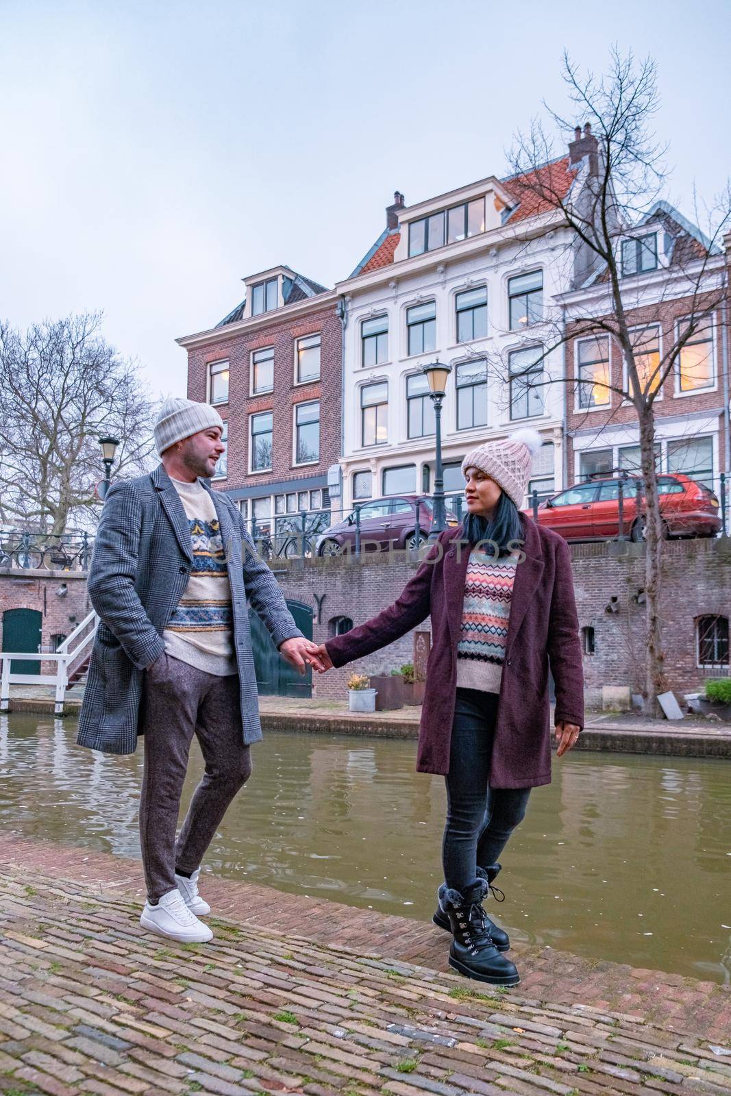 couple on a city trip in Utrecht, mid age Asian woman and European men visit Utrecht, Traditional houses on traditional houses on the Oudegracht Old Canal in the center of Utrecht, Netherlands Holland Europe