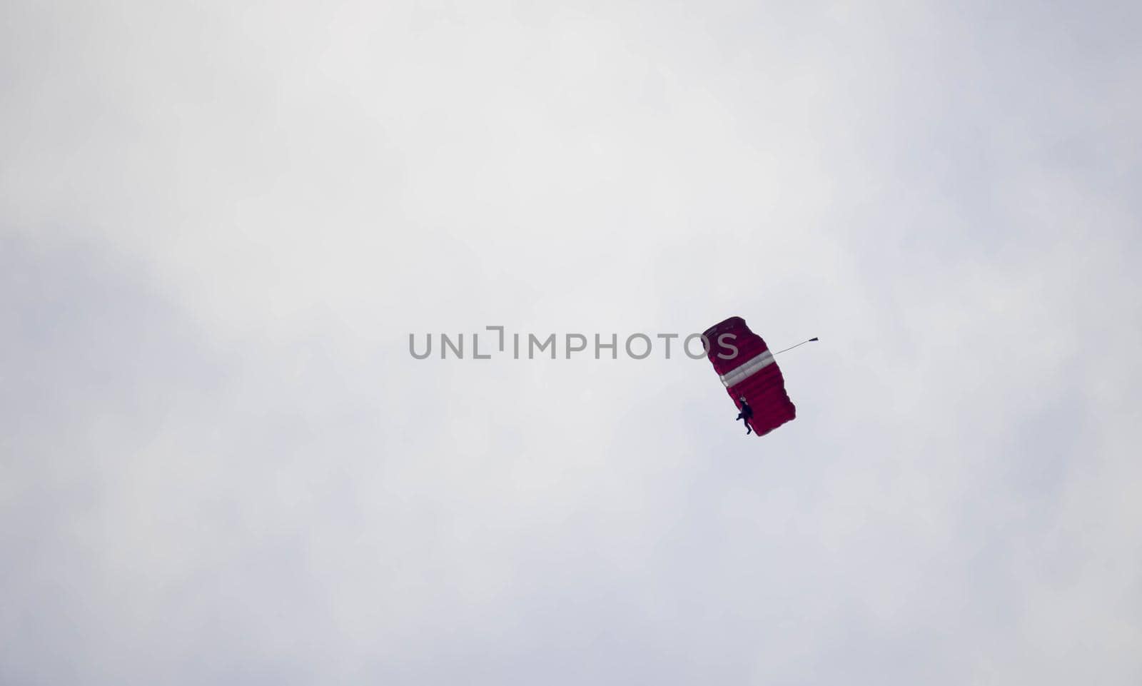 silhouette parachute stunt unfocused and blurry while gliding in the air with blue sky