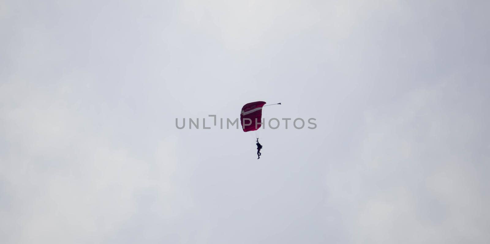 silhouette parachute stunt unfocused and blurry while gliding in the air with blue sky