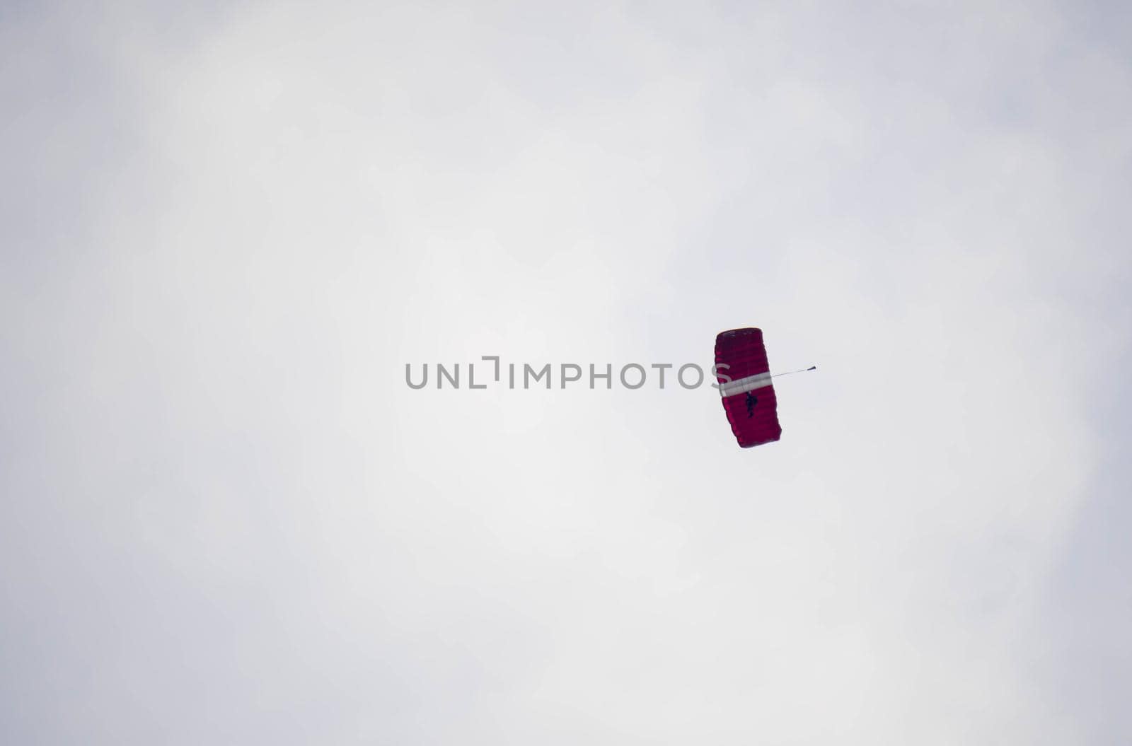 silhouette parachute stunt unfocused and blurry while gliding in the air with blue sky