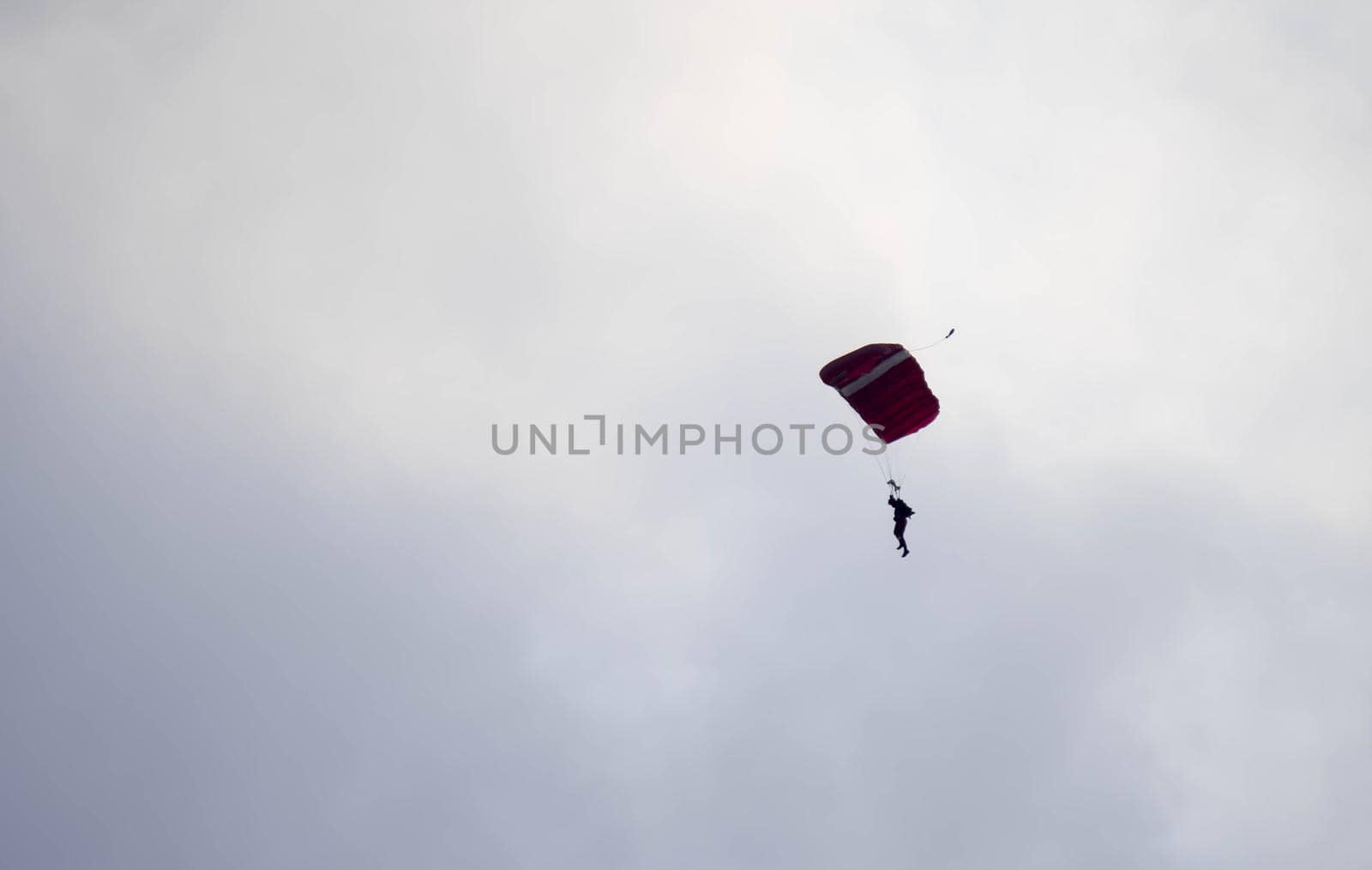 silhouette parachute stunt unfocused and blurry while gliding in the air with blue sky