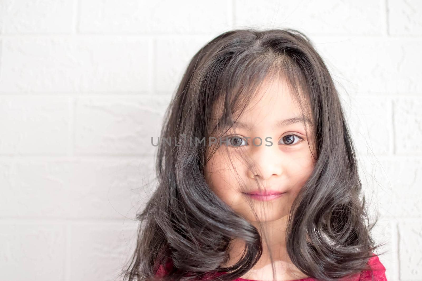 A Fashion model and beauty look. Stylish girl with pretty face on grey background. Hairdresser, skincare, casual style. Beauty and kid fashion with healthy hair. Little girl with long hair.