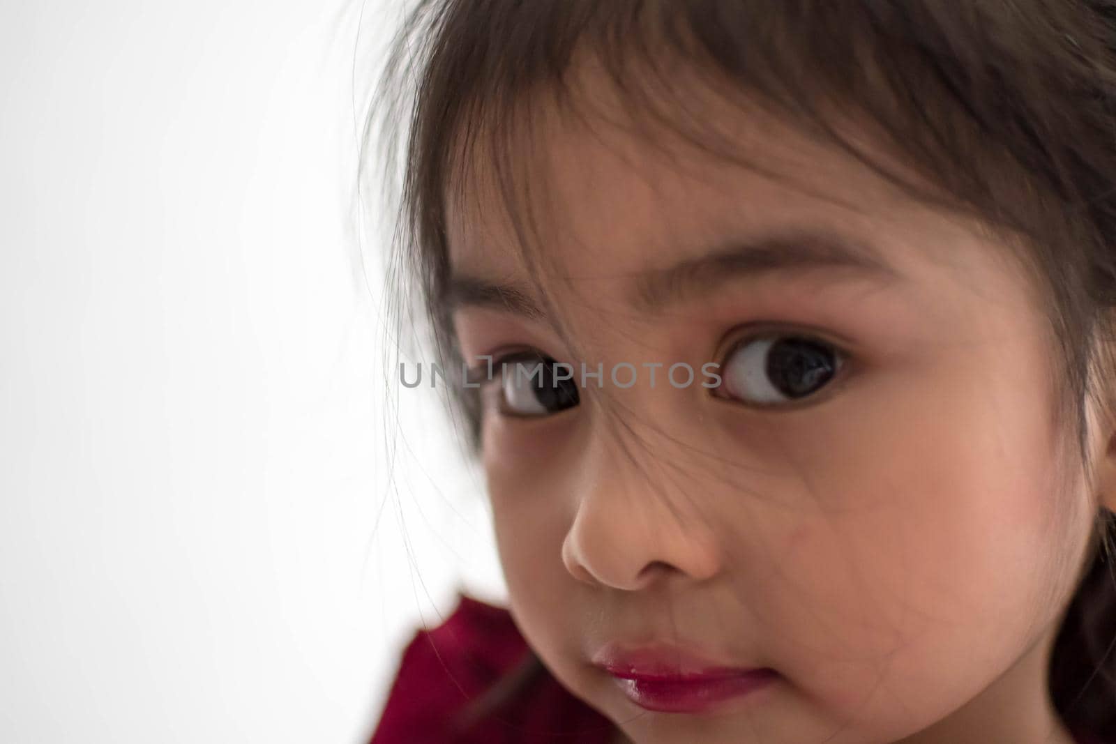 Pretty cute little girl while having a makeup, lipstick and blush on