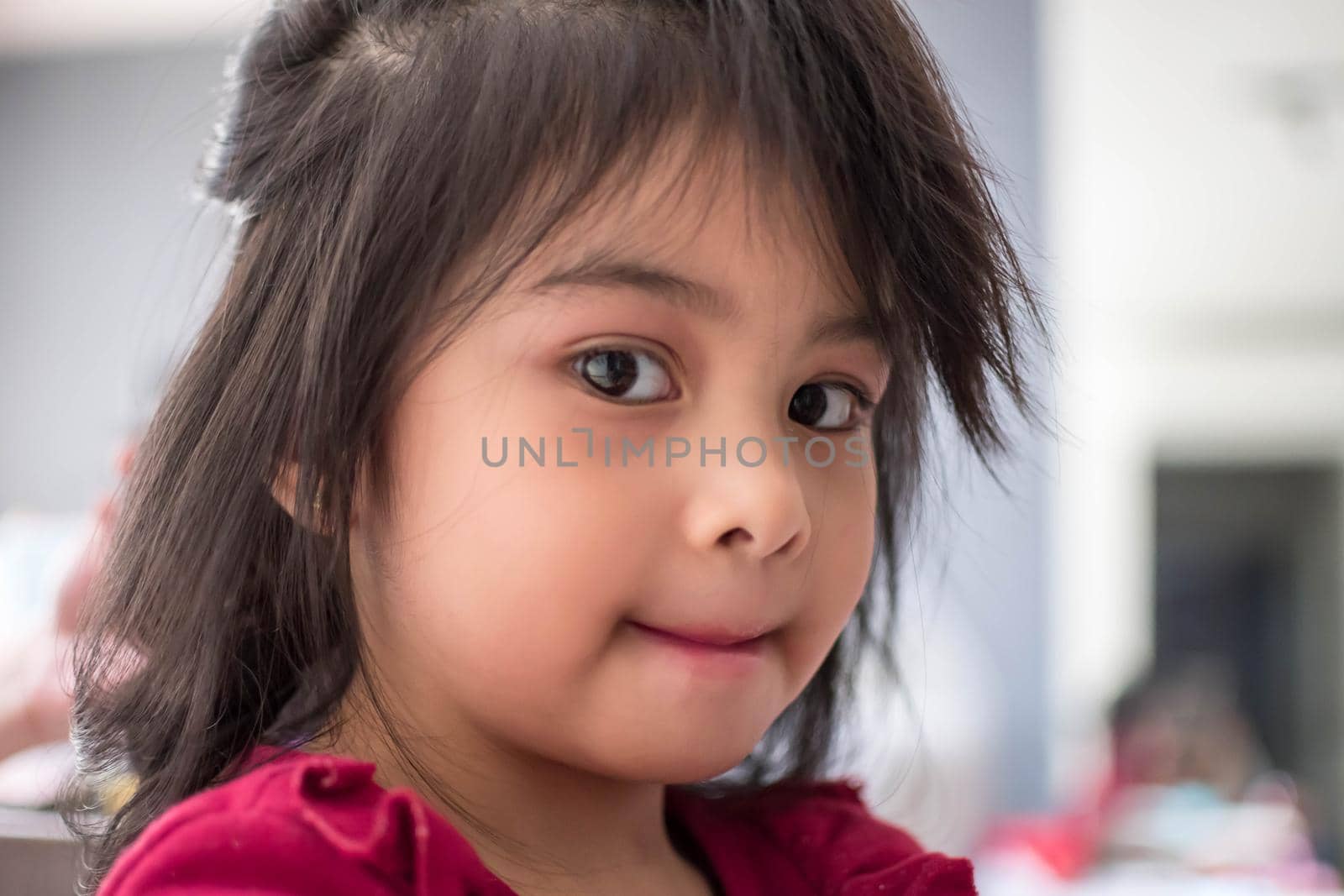 Pretty cute little girl while having a makeup, lipstick and blush on