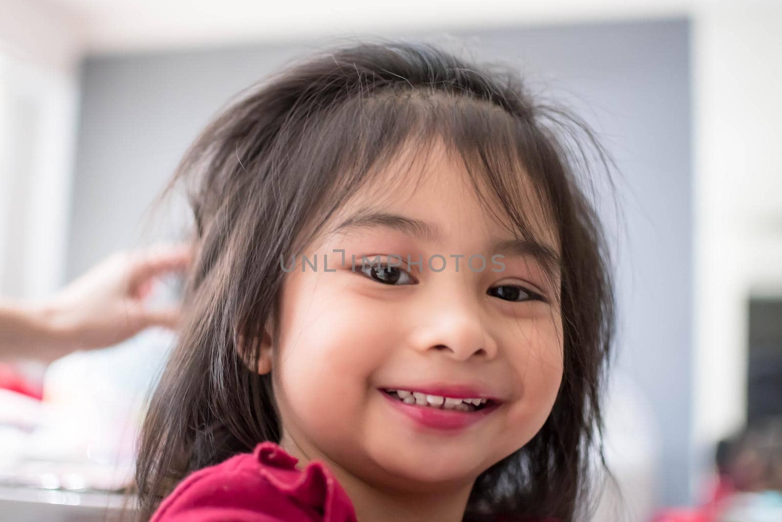 Pretty cute little girl while having a makeup, lipstick and blush on