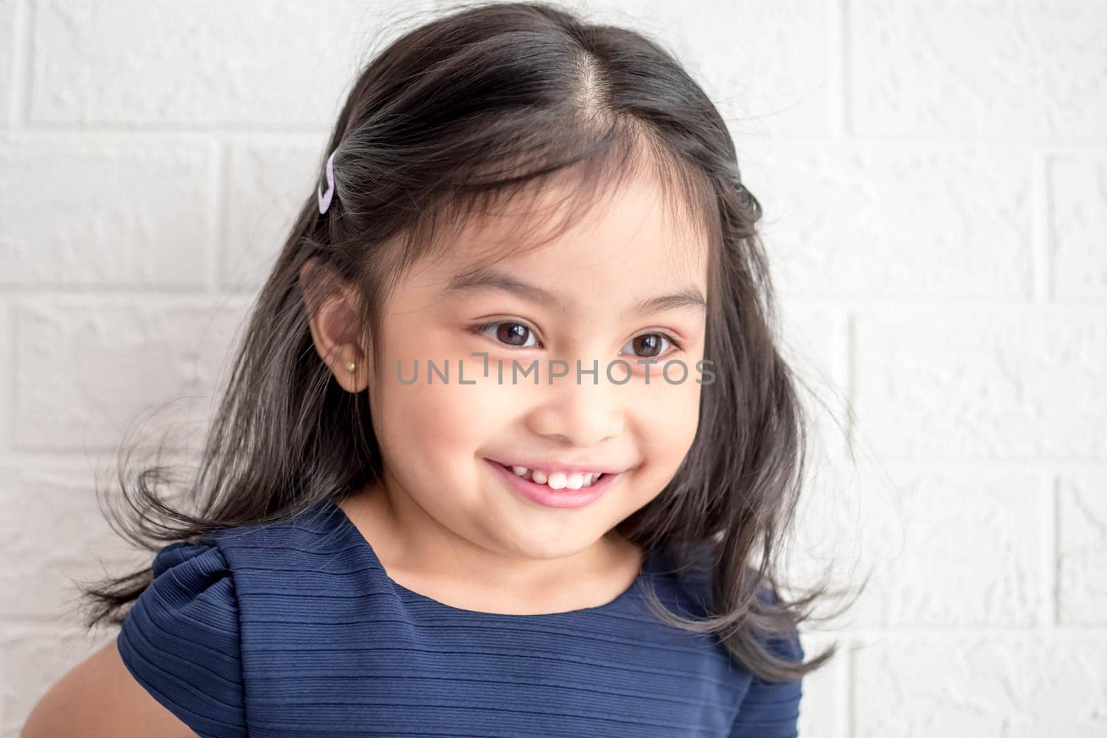 A Fashion model and beauty look. Stylish girl with pretty face on grey background. Hairdresser, skincare, casual style. Beauty and kid fashion with healthy hair. Little girl with long hair.