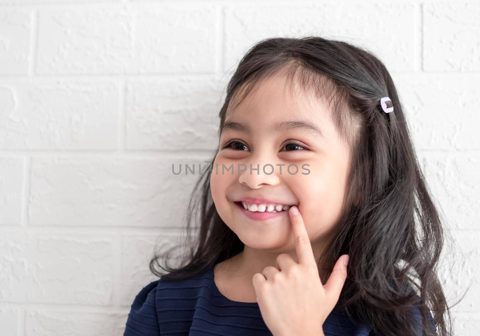 A Fashion model and beauty look. Stylish girl with pretty face on grey background. Hairdresser, skincare, casual style. Beauty and kid fashion with healthy hair. Little girl with long hair.