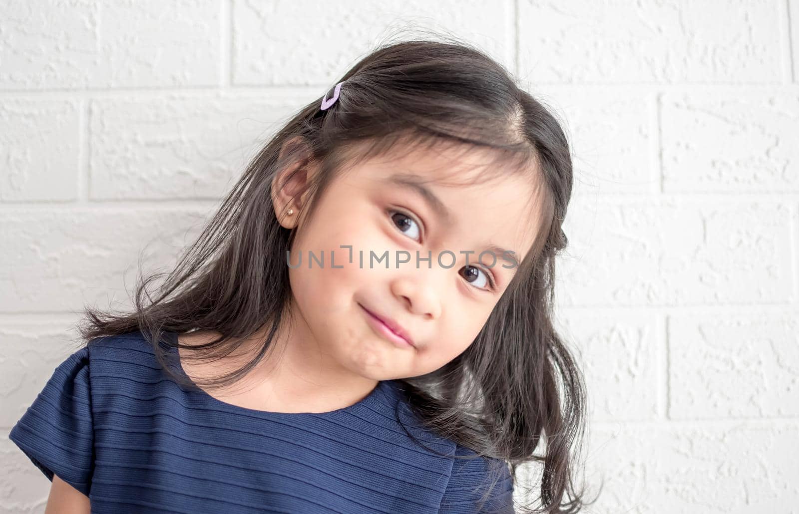 A Fashion model and beauty look. Stylish girl with pretty face on grey background. Hairdresser, skincare, casual style. Beauty and kid fashion with healthy hair. Little girl with long hair.