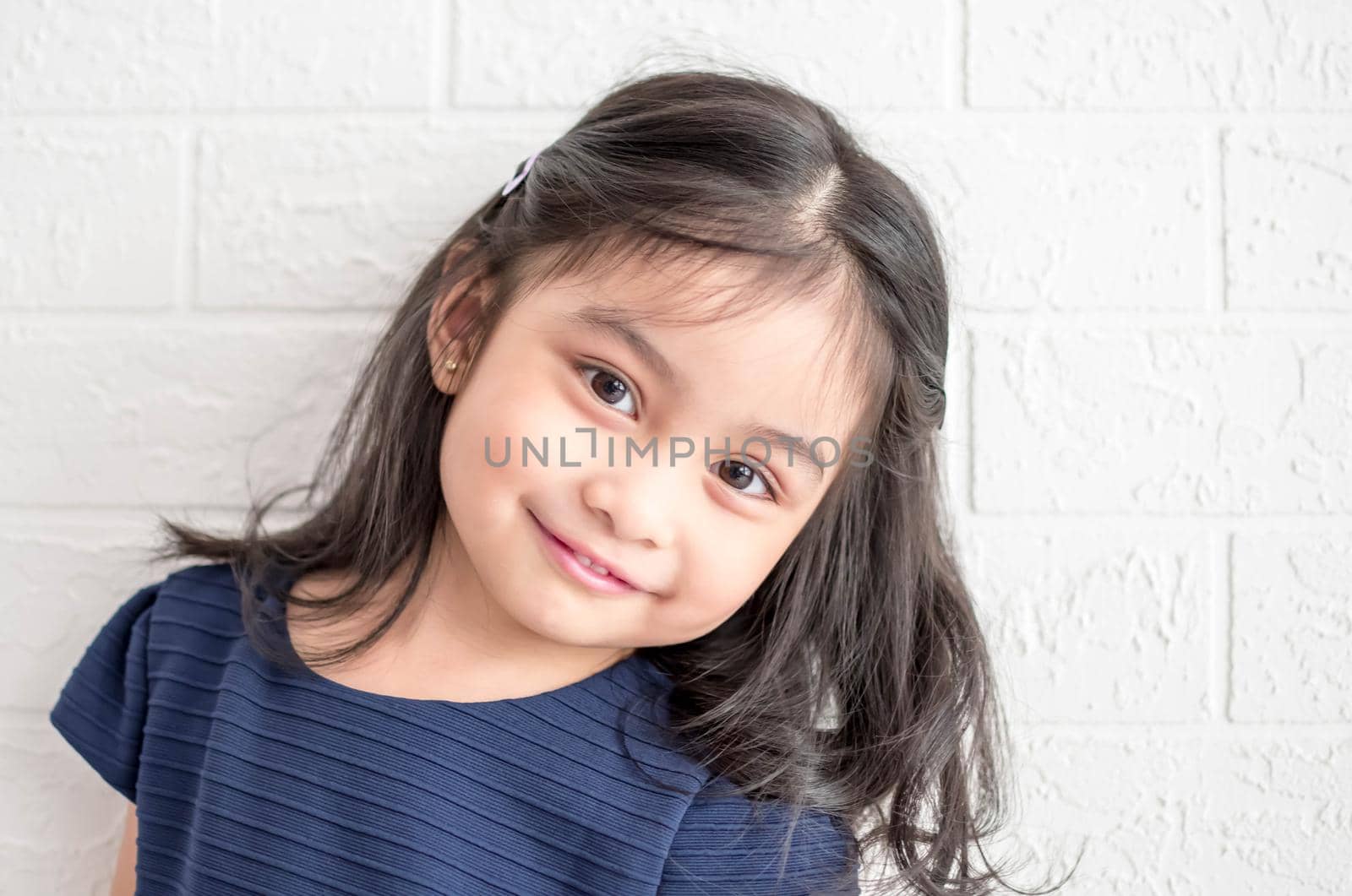 A Fashion model and beauty look. Stylish girl with pretty face on grey background. Hairdresser, skincare, casual style. Beauty and kid fashion with healthy hair. Little girl with long hair.