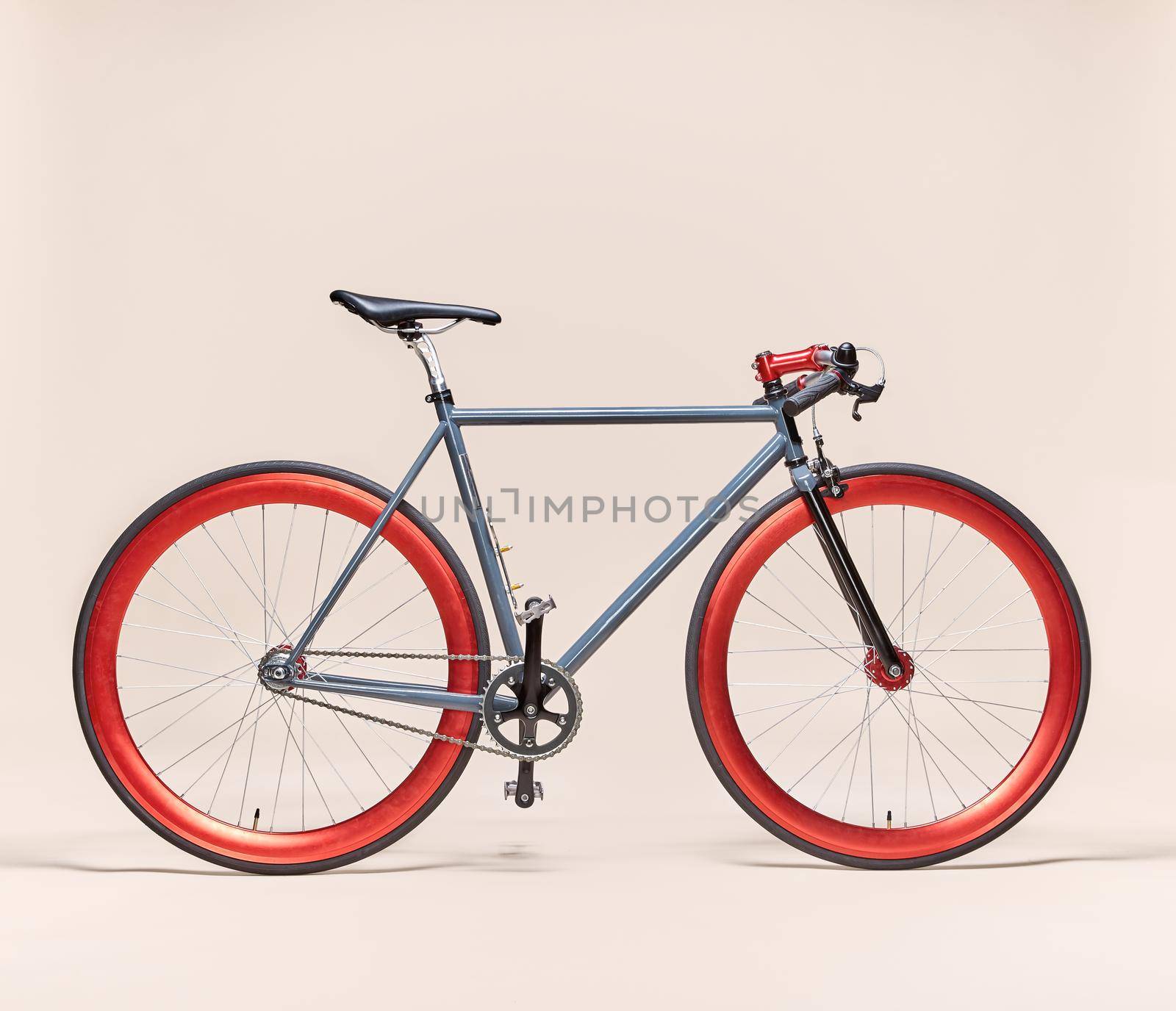 Trendy blue and red bicycle isolated on a pale pink background