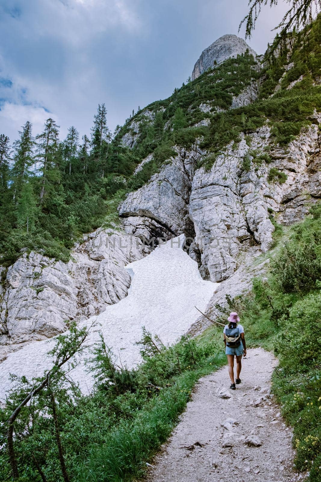 woman hiking to blue green lake in the Italian Dolomites,Beautiful Lake Sorapis Lago di Sorapis in Dolomites, popular travel destination in Italy. Europe