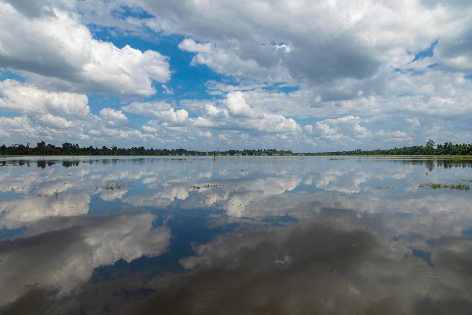 Landscape with clouds reflected on the water, in the lake surrounding the Buddhist Neak Pean temple, in the archaeological complex of Angkor, near the city of Siem Reap, Cambodia.