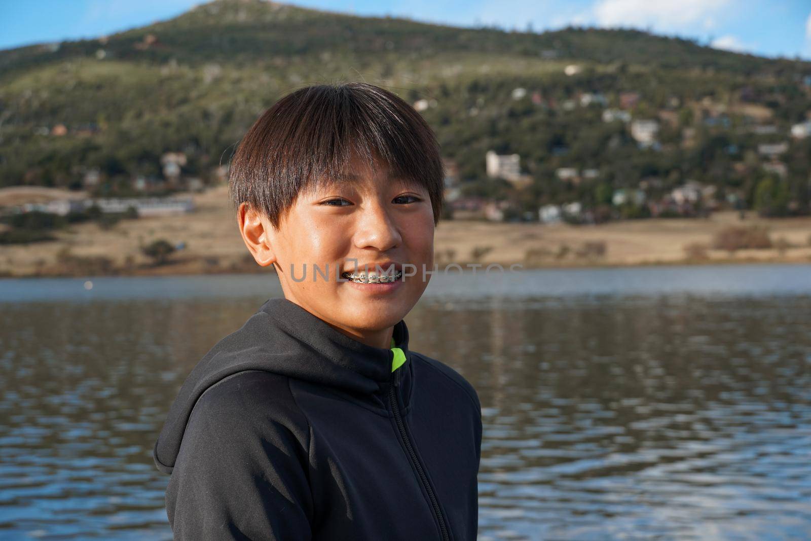 Portrait of young sporty Asian boy by the Lake. Teenager concept