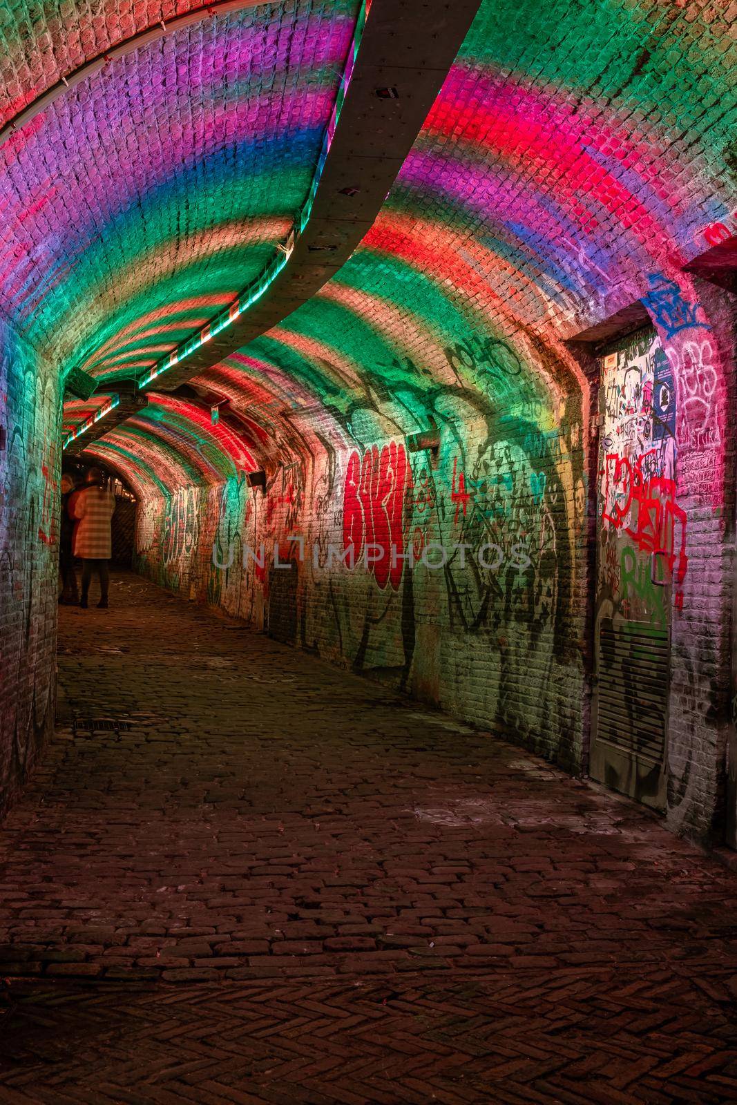 colorful green, blue, pink illuminated Ganzemarkt tunnel in the centre of Utrecht, The Netherlands by fokkebok