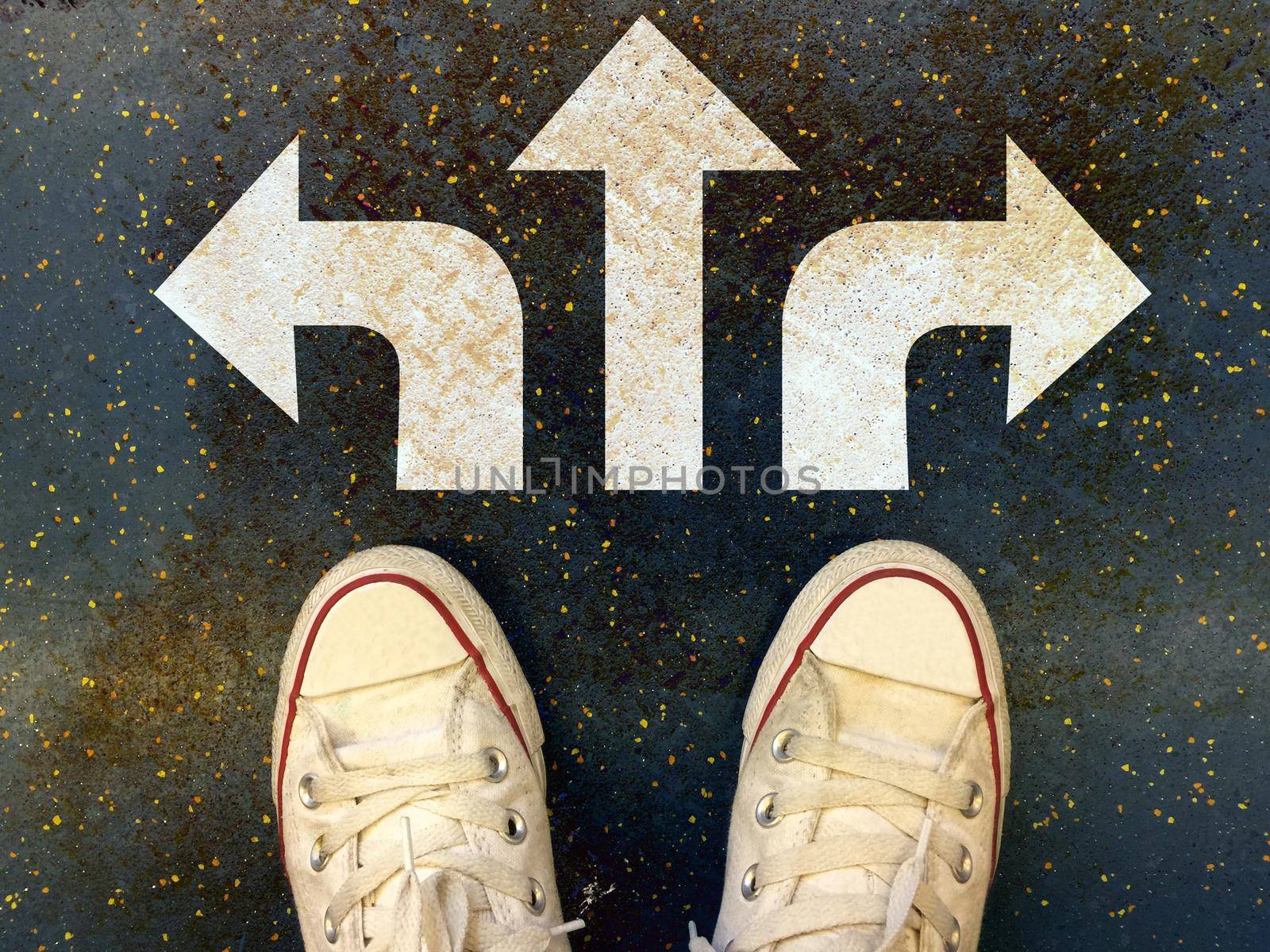 Sneakers shoes with three white arrows print pointing on grunge road , making decision business concept