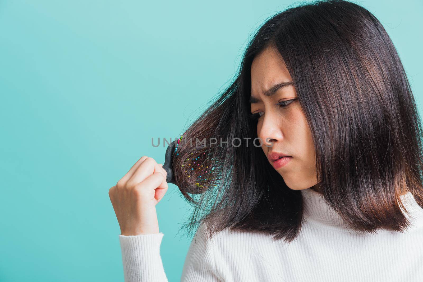 woman upset with a comb and problem hair by Sorapop