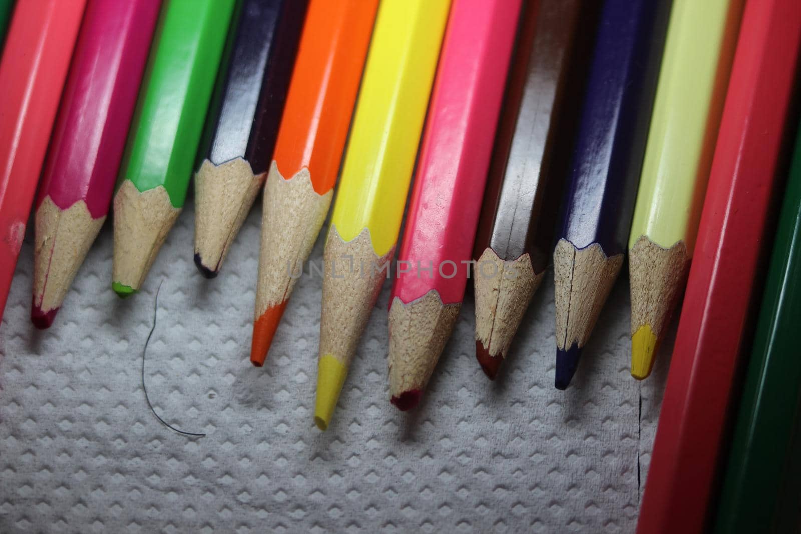 Close-up view of bright colored multicolor pencils on black background