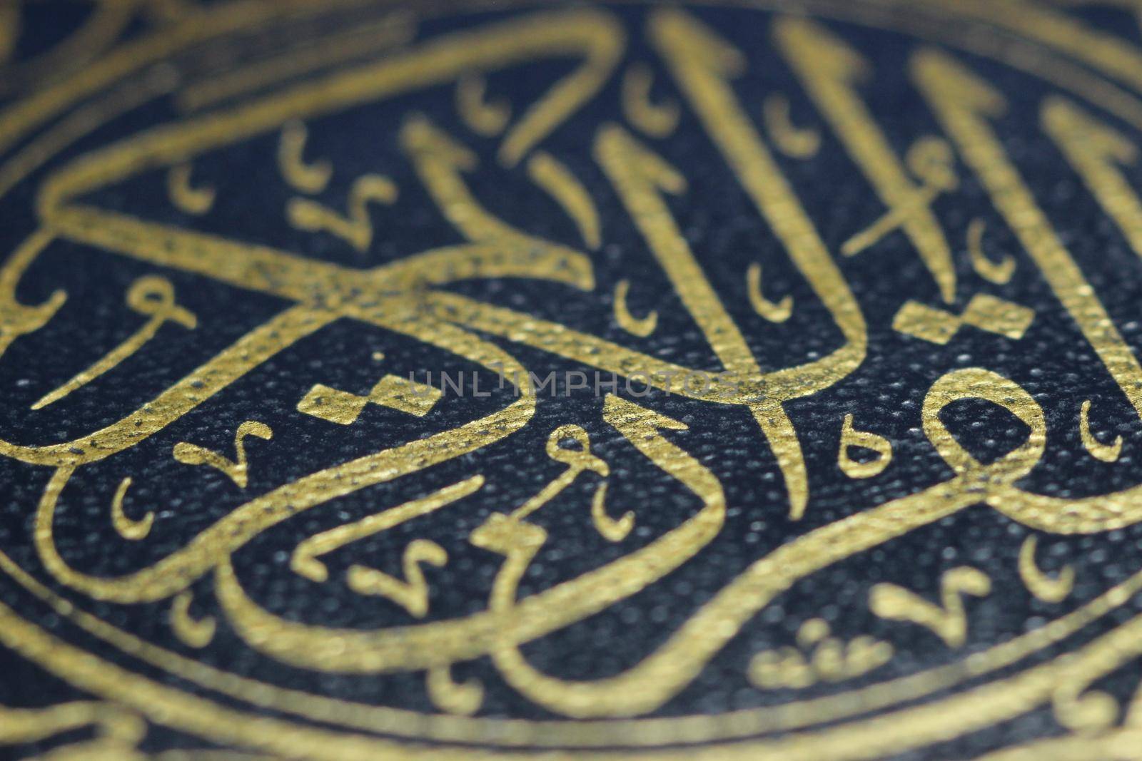 Closeup shot of Islamic Book Quran with golden arabic calligraphy that means Al-Quran, the Holy Quran