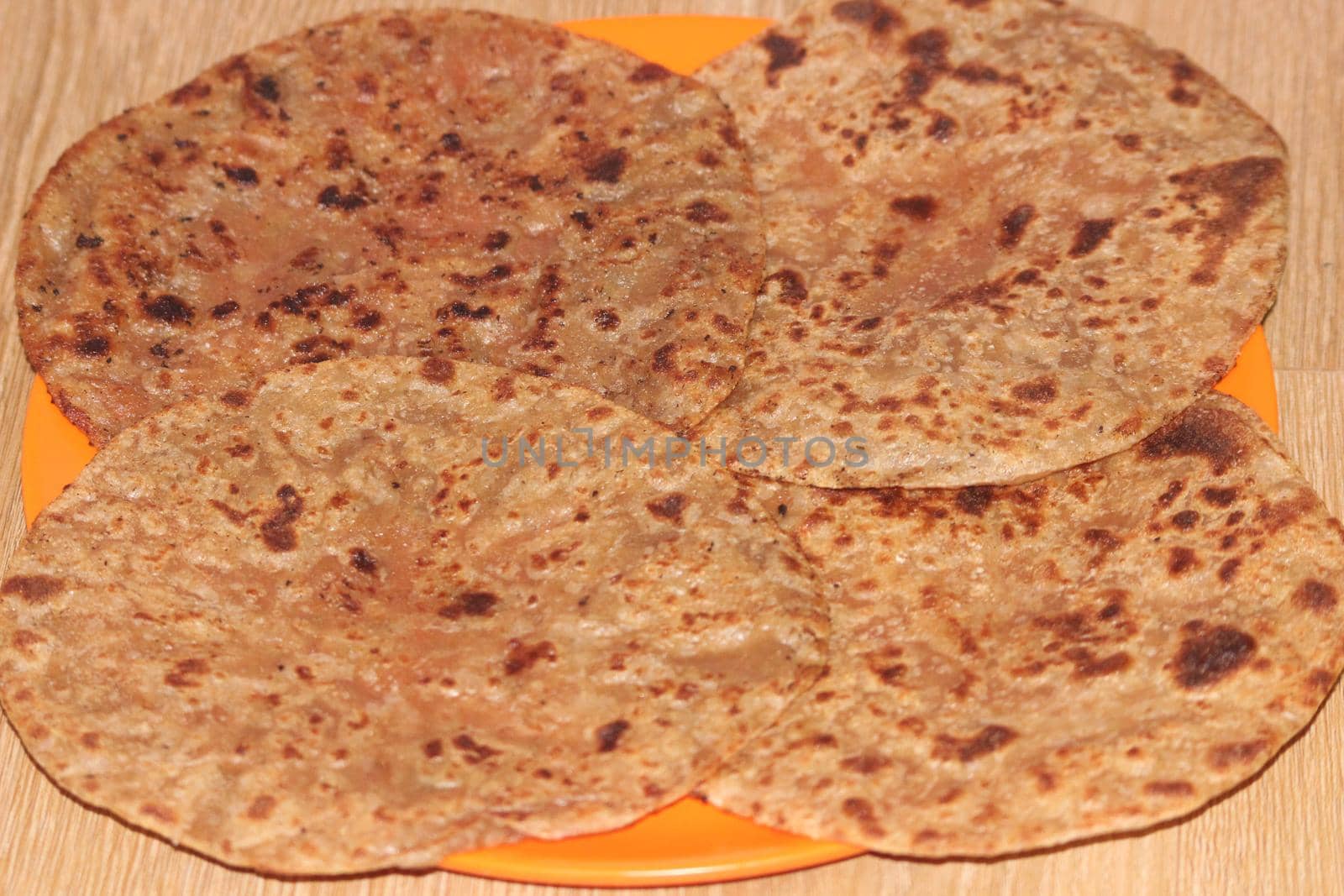 Traditional paratha - Macro closeup with selective focus of homemade oily bread or parotta on a plate. Chapati is traditional food of southeast Asia.